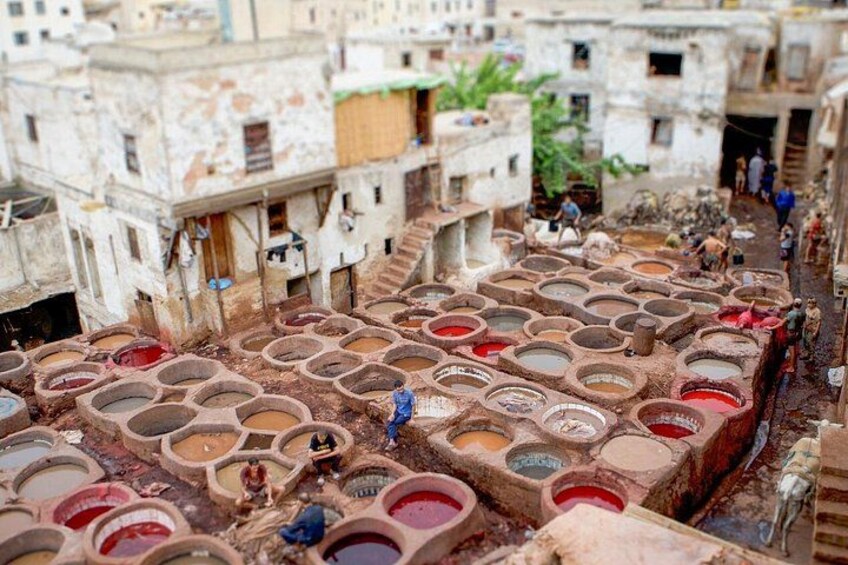 A traditional dyeing area with large vats and workers. 1