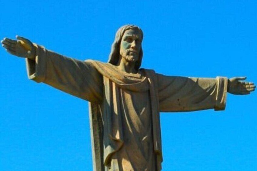 Eine Statue mit ausgestreckten Armen vor strahlend blauem Himmel. 5