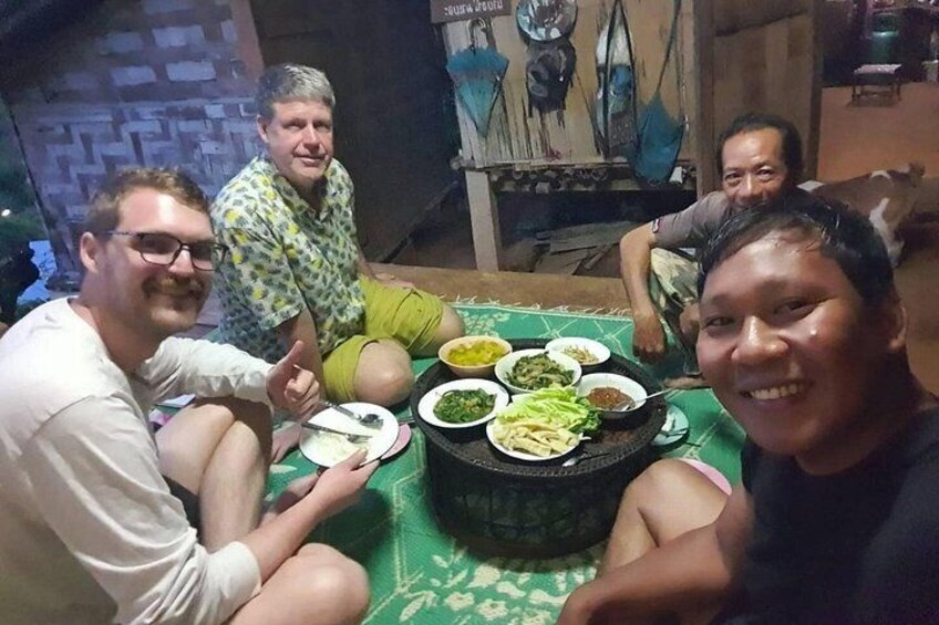 A group of people sitting around a table with various dishes. 4