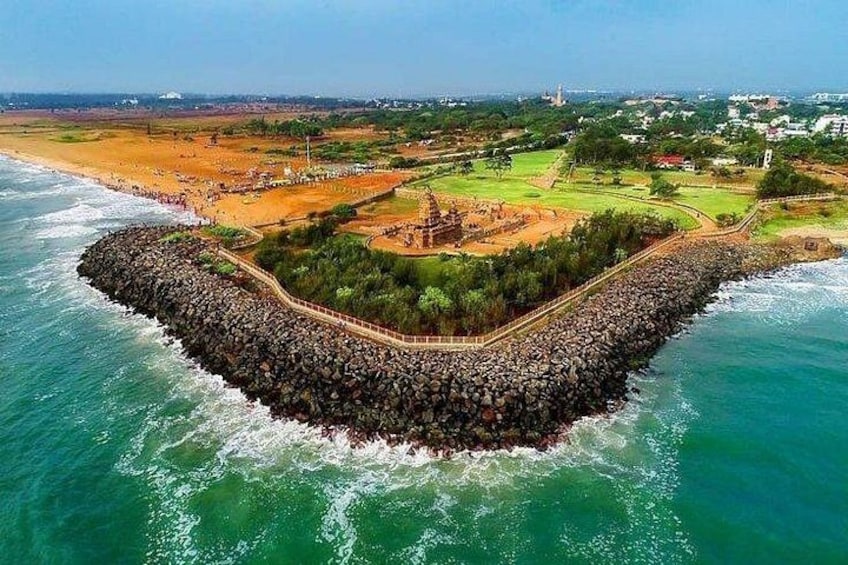 A coastal area with a rocky breakwater, a beach, and a golf course. 3