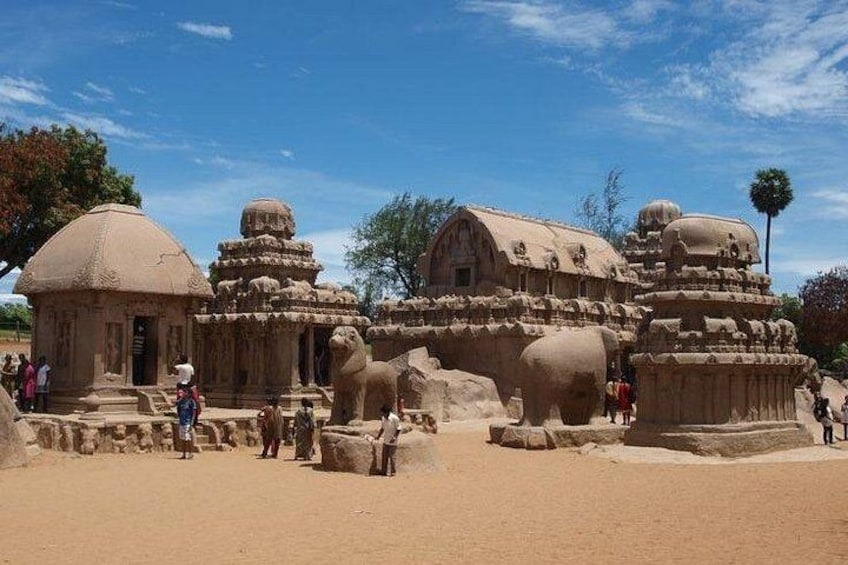 Ancient stone structures, including a temple with a dome and intricate carvings, surrounded by visitors. 2