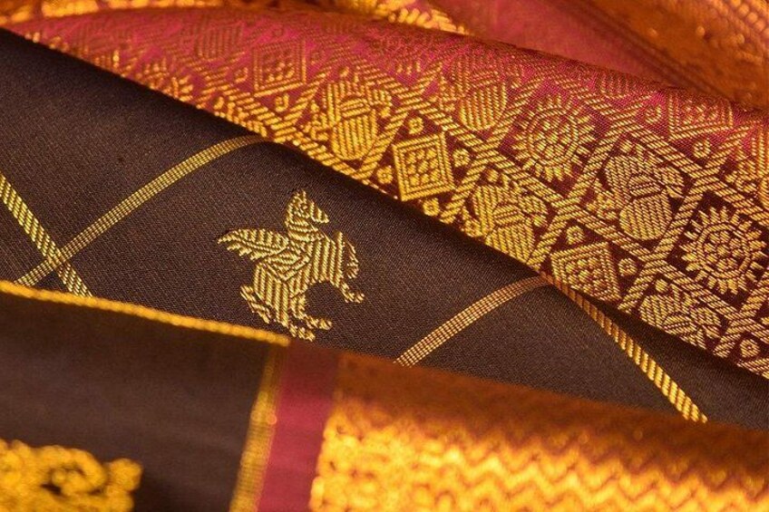 A fabric with intricate golden embroidery and a pattern of a horse. 5