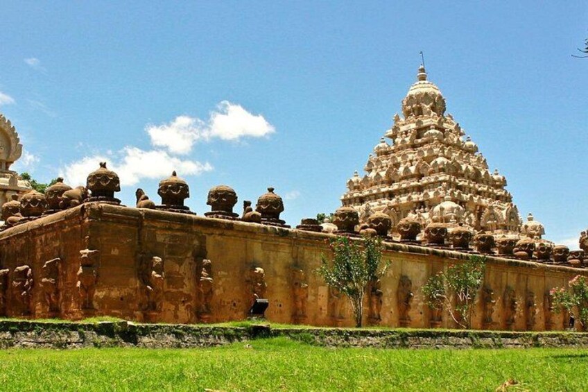 A temple with a tiered tower and a long wall with statues. 1