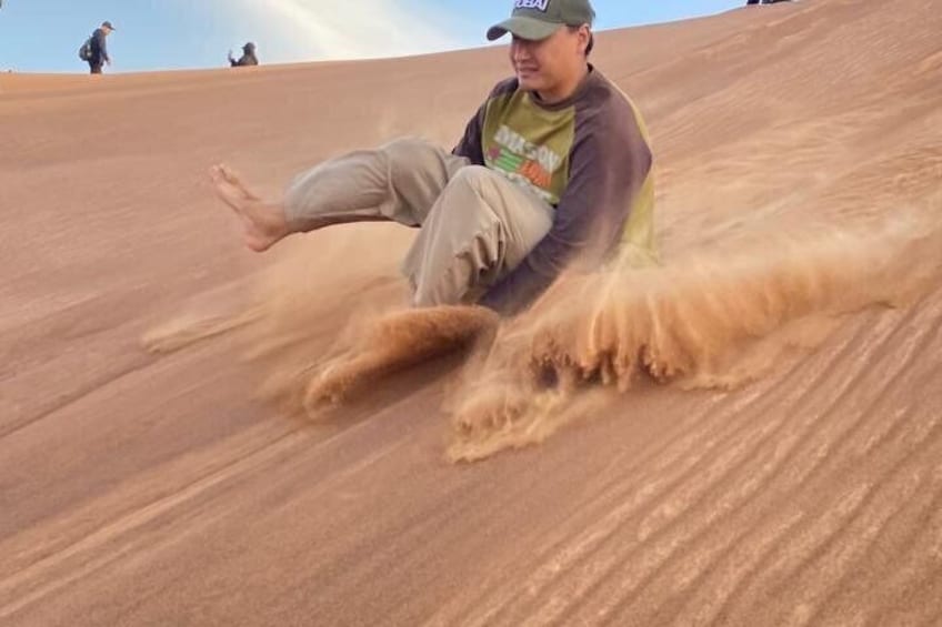 A person sliding down a sandy slope. 3