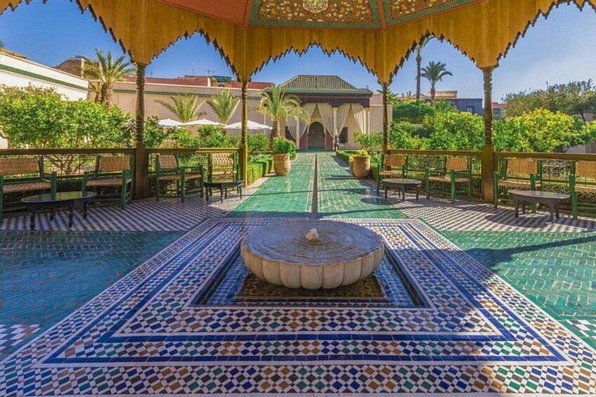 A courtyard with patterned tiles, a fountain, and a traditional building in the background. 3