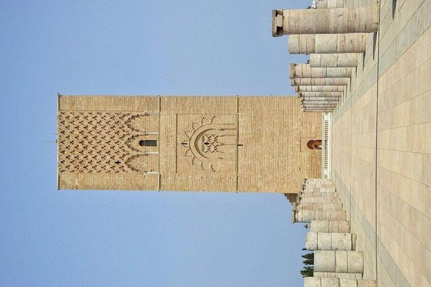 A tall, rectangular tower with intricate carvings and a circular emblem at the top. 4