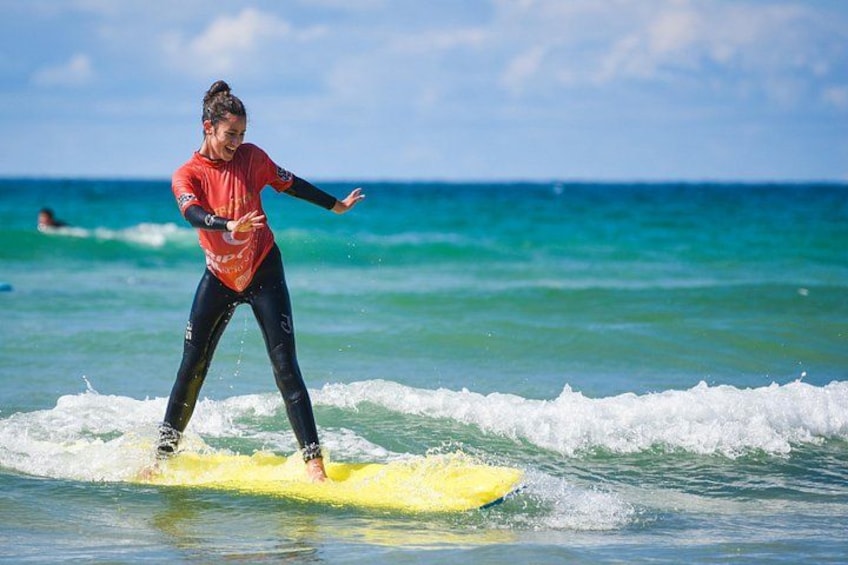 A person surfing on a yellow board in the ocean. 3