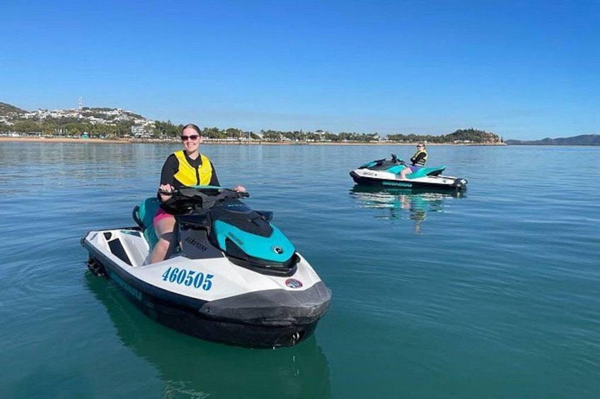 Deux personnes sur des scooters des mers sur un lac calme, sous un ciel dégagé. 2
