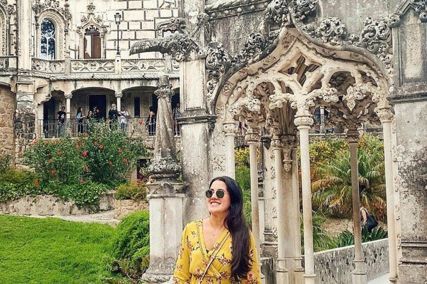 A historic building with ornate architecture, a well-maintained garden, and a person in a yellow dress. 3