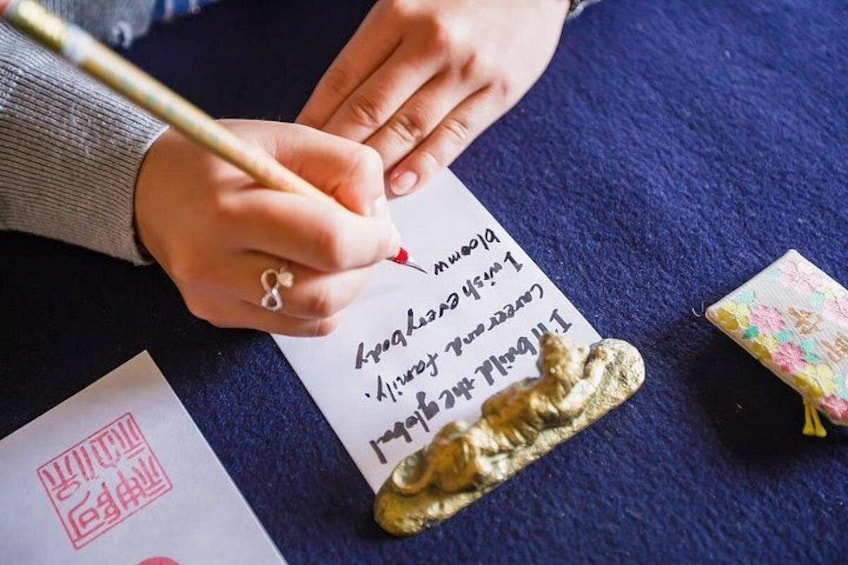A person writing on a piece of paper with a pen. 2