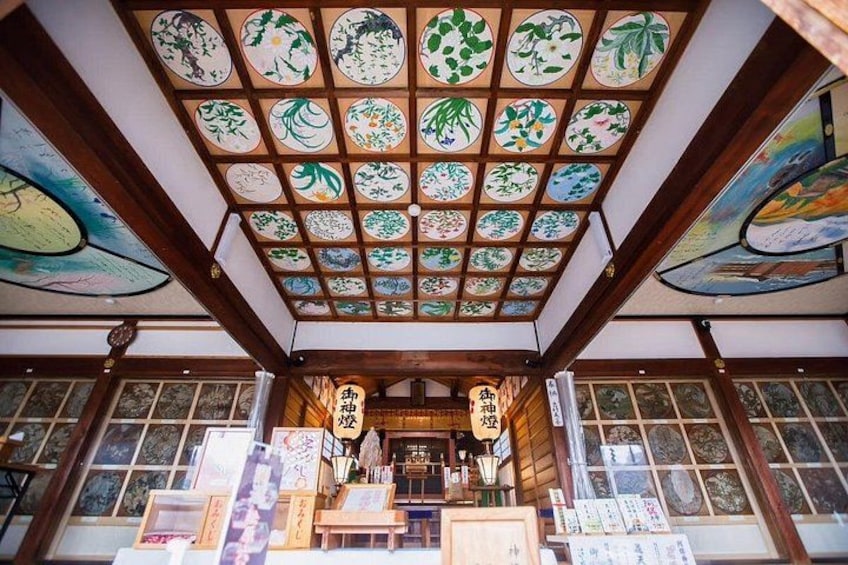Un interior japonés tradicional con suelo de tatami, un celosía de papel shoji y un techo con una serie de pergaminos colgantes. 3