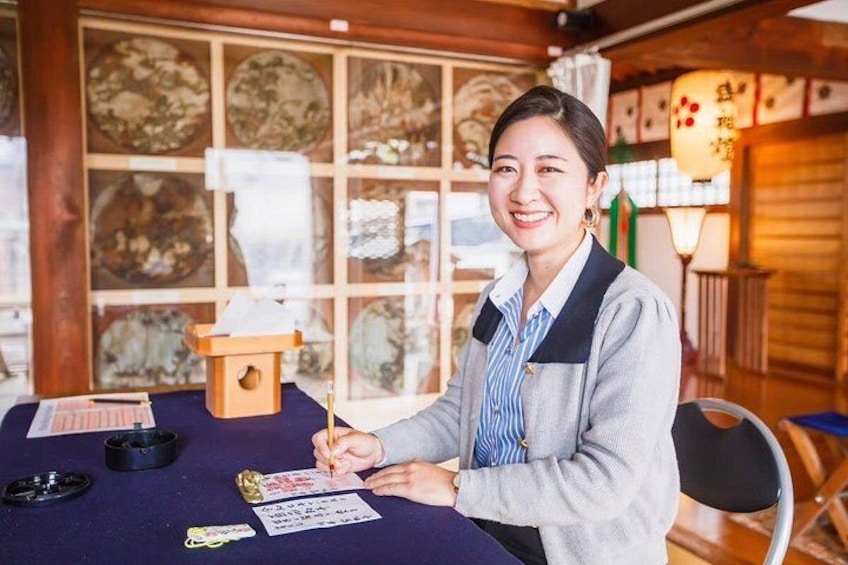 A person sitting at a table with a notepad, pen, and a small wooden box. 5