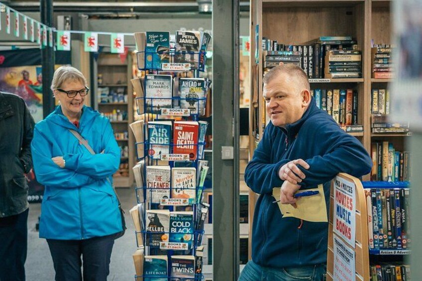 A bookstore with bookshelves and a display rack filled with books. 4