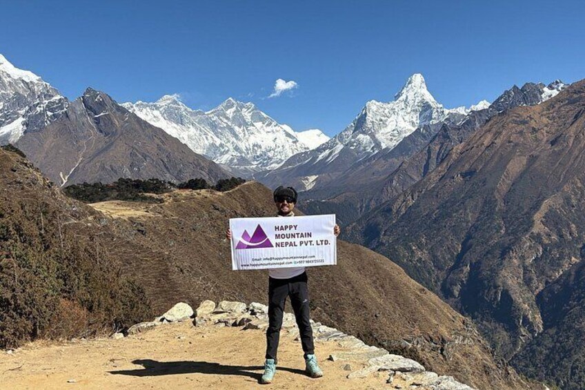 Une personne tenant une pancarte devant elle, avec une chaîne de montagnes en arrière-plan. 3