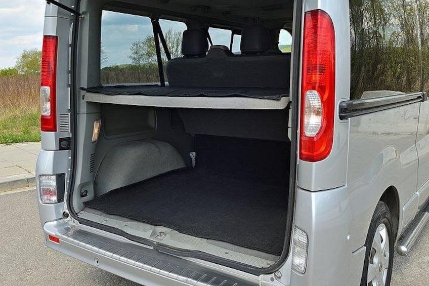 A silver van with an open cargo area, rear lights, and a visible license plate. 2