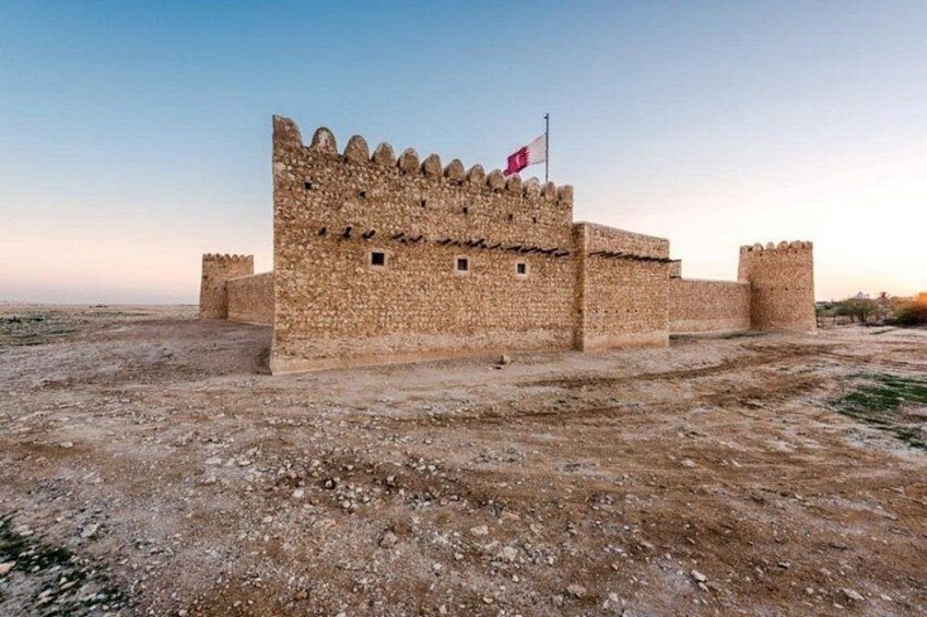 A stone fortress with a flag, surrounded by a barren landscape. 4