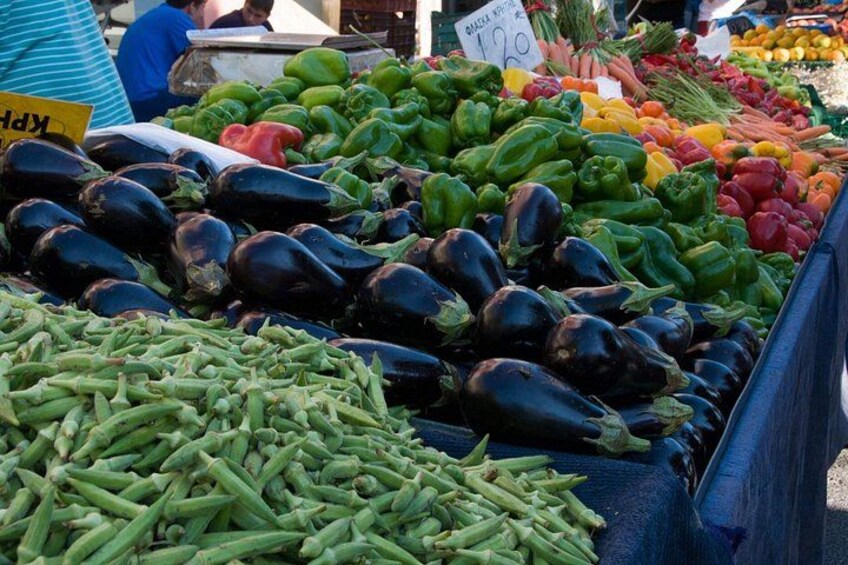 A vegetable market with eggplants, green beans, and bell peppers. 2
