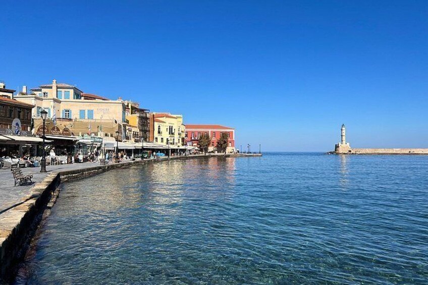 A waterfront with buildings, a pier, and a lighthouse. 5
