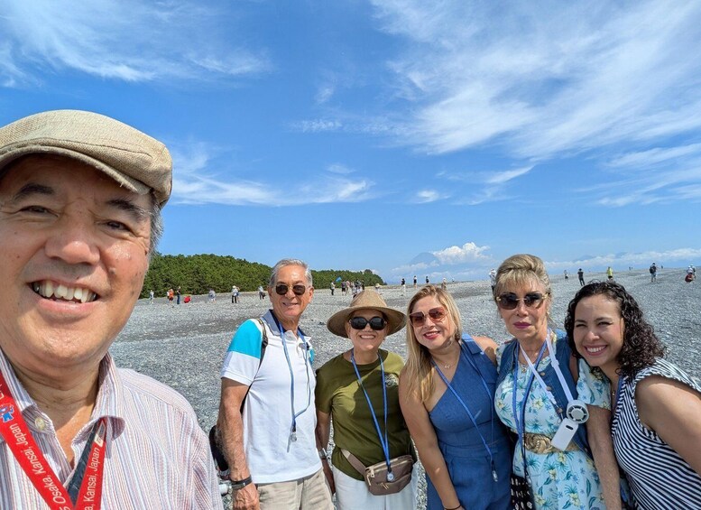 A group of people at a beach with a clear sky and distant mountains. 5