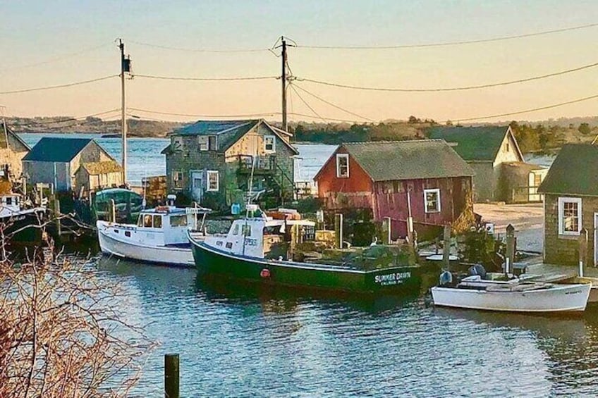 A harbor with boats docked, houses, and a clear sky. 3