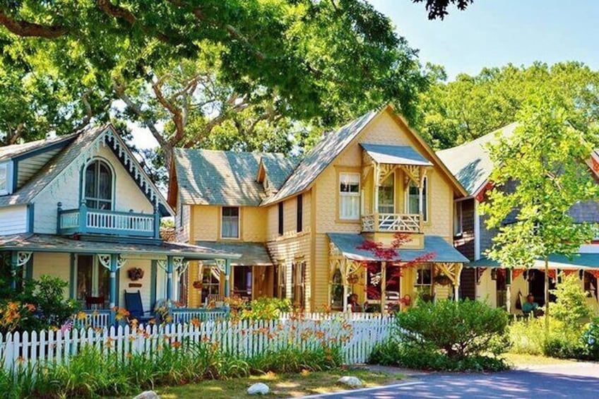 A row of charming, colorful houses with a white picket fence and lush greenery. 2