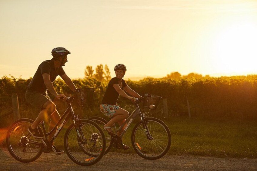 Twee mensen fietsen op een weg in de zonsondergang. 2