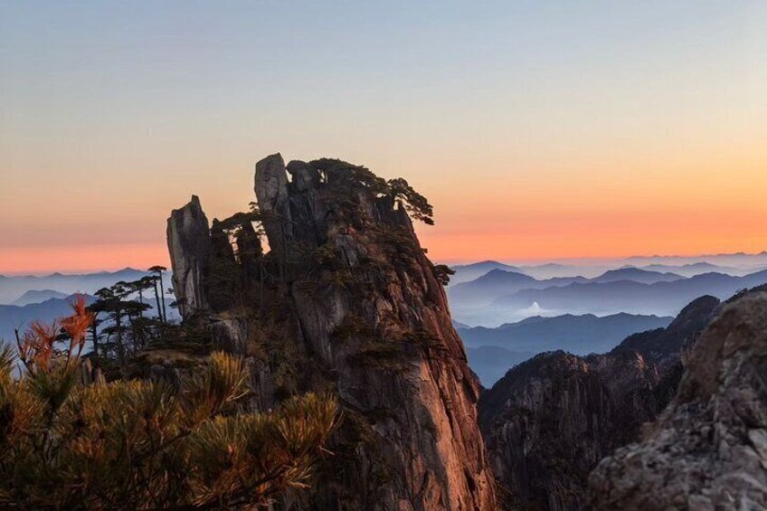 Un sommet montagneux rocheux, avec une végétation clairsemée, au coucher du soleil. 3