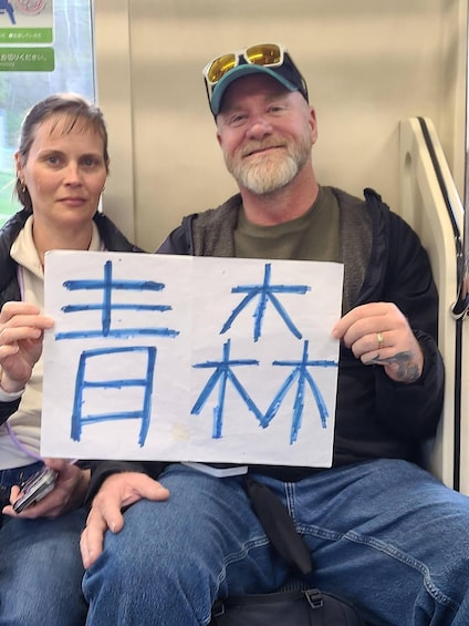 Two people holding a sign with Japanese characters. 2