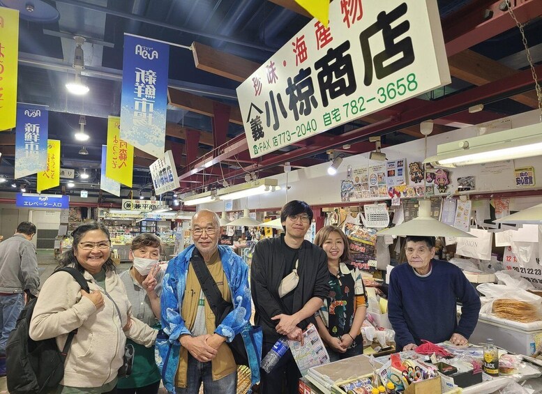 A group of people in a market with various signs and goods on display. 4