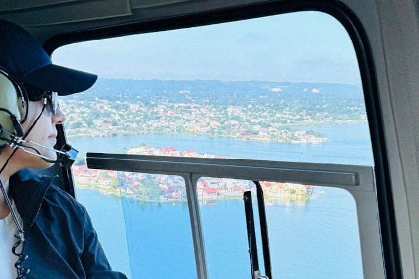 Eine Person im Cockpit mit Blick auf einen See und eine Stadt. 3