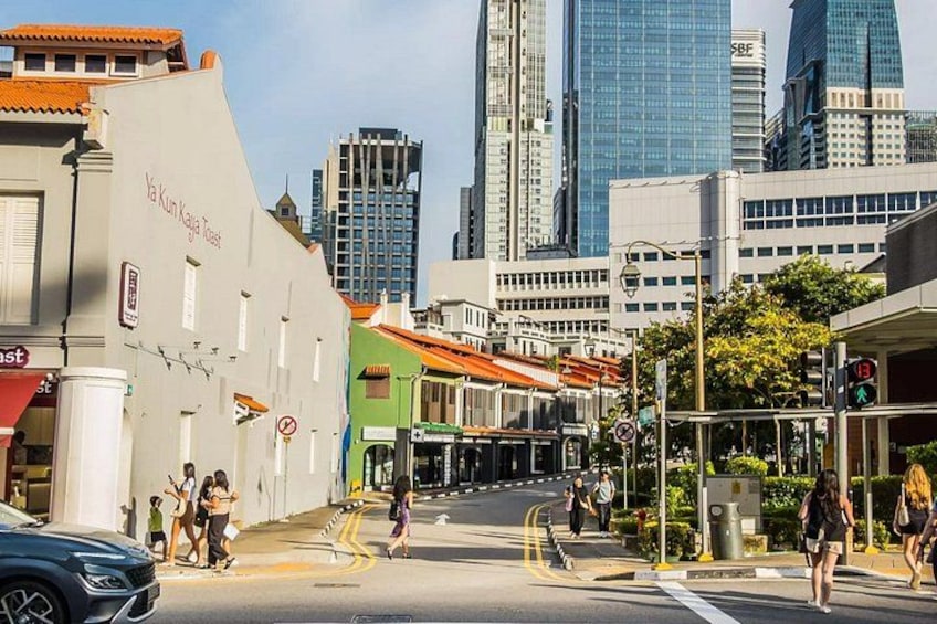 A city street with pedestrians, a tram, and modern buildings. 3