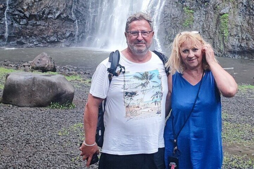 A waterfall with rocks and a person in a blue dress. 5