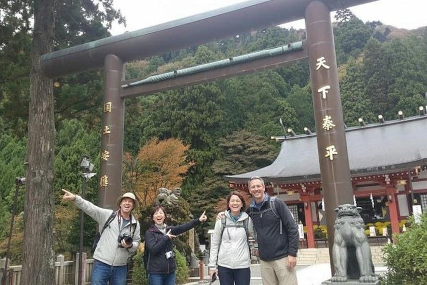 Un groupe de personnes se trouve à l’entrée d’un temple, avec une grande arche et une pagode en arrière-plan. 1