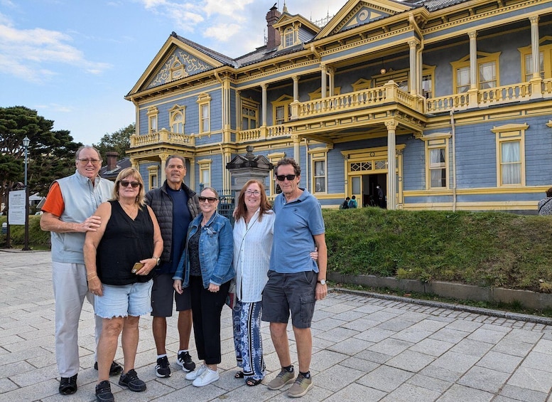 A group of people standing in front of a large, ornate building with a blue and yellow facade. 5