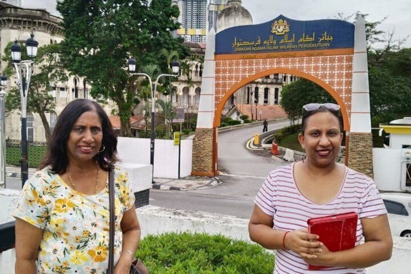 Two women standing in front of a building with an archway. 5