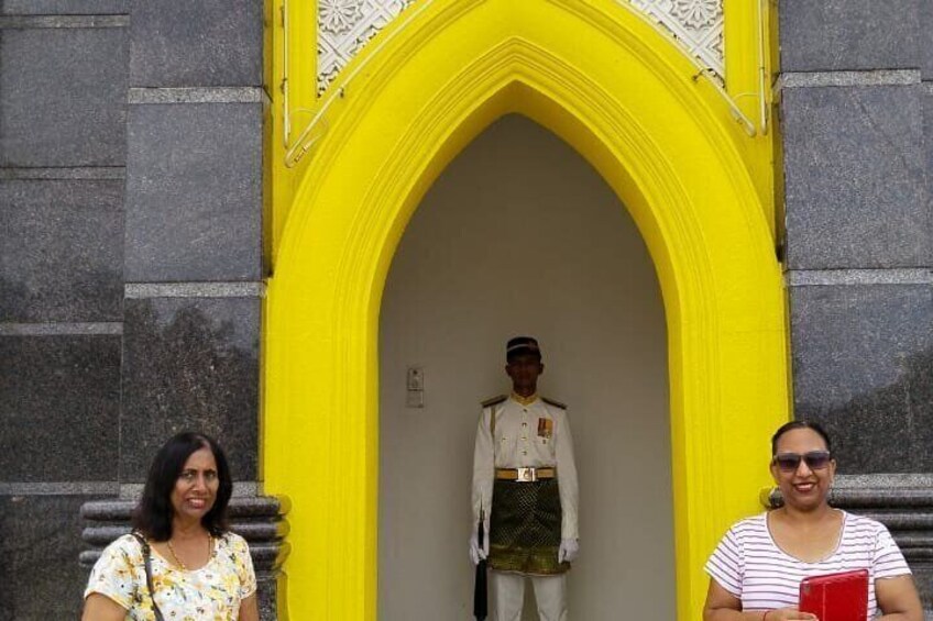 A yellow archway with a uniformed guard standing inside. 3