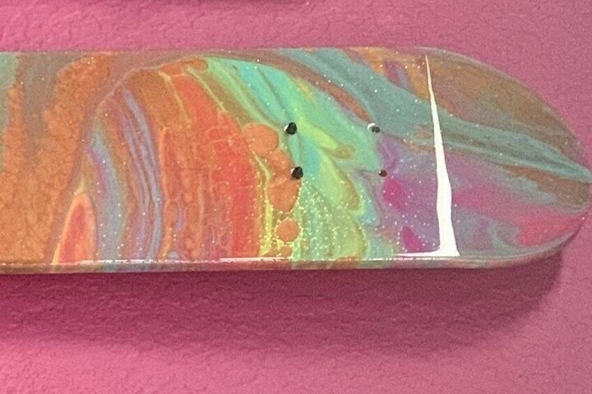 Un monopatín con un diseño colorido tipo mármol. 3