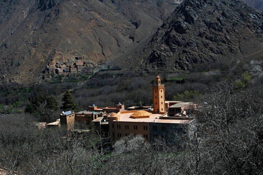 A mountainous village with traditional buildings and a prominent minaret. 2