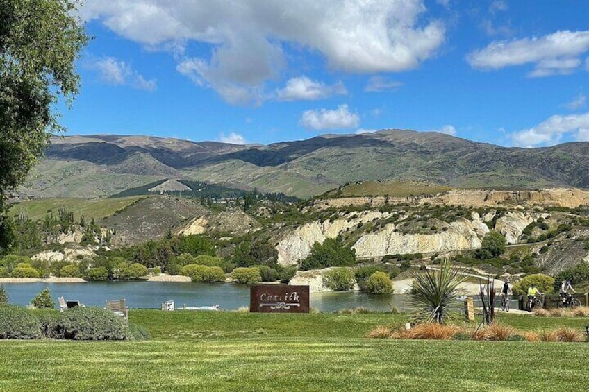 Un lago circondato da colline, un cartello con la scritta 'Capitol' e un cielo azzurro terso. 3