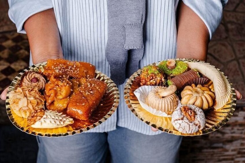 Una persona che tiene in mano due piatti di dolci misti. 3