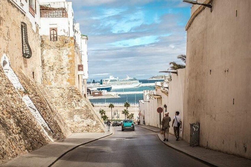 Una strada costiera con vista sul mare e una nave da crociera in lontananza. 2