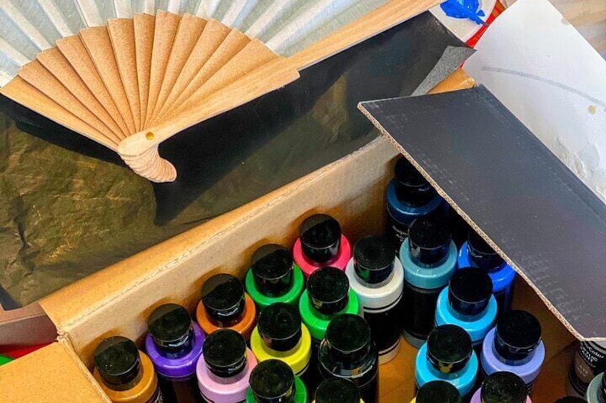 Un cassetto contenente vari barattoli di vernice colorata e un ventaglio di legno. 2