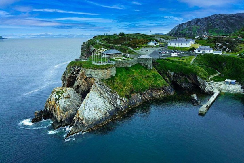 A coastal town with a prominent lighthouse, a pier, and a rugged coastline. 1