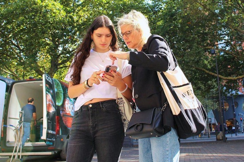 Deux personnes se tiennent sur un trottoir, l’une d’elles tenant un téléphone intelligent. 4