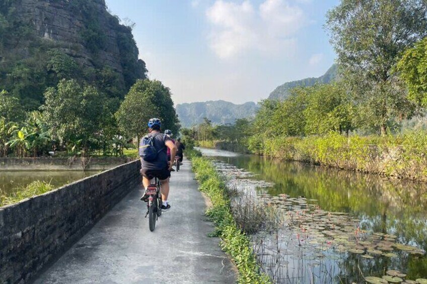 Un camino pavimentado junto a un río con ciclistas. 1