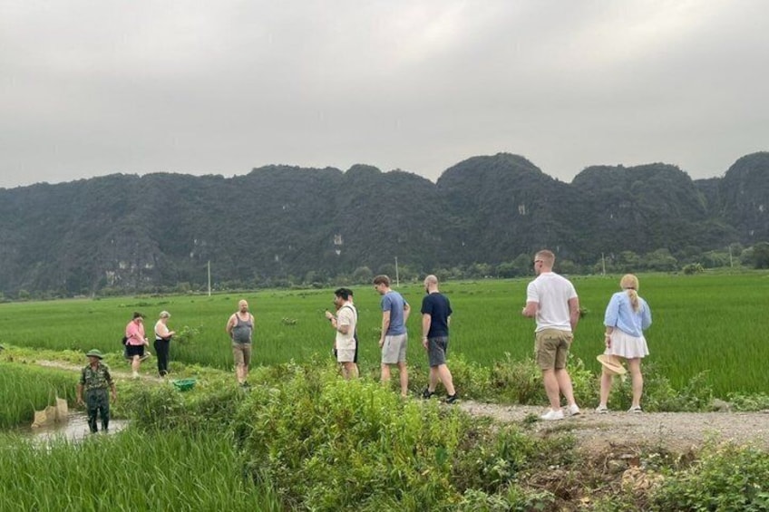 A group of people standing in a field with a mountainous backdrop. 3