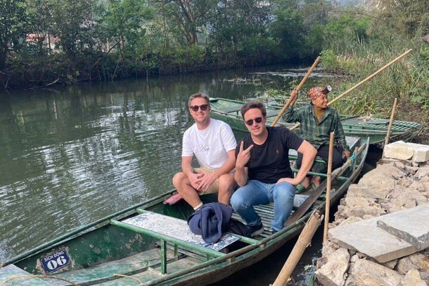 Deux personnes dans un bateau vert sur une rivière paisible, entourées de verdure. 5