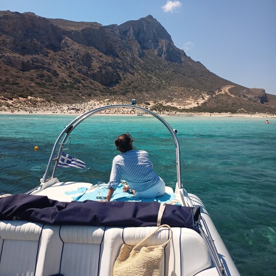 A person on a boat with a mountainous landscape in the background. 2
