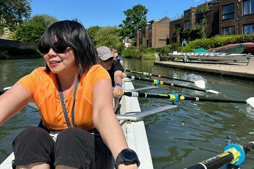 En person i en robåd på en kanal med bygninger i baggrunden. 4