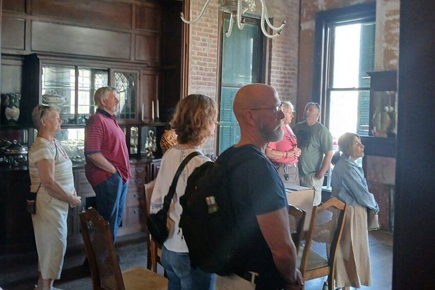 Eine Gruppe von Menschen in einem rustikalen Innenraum mit Backsteinwänden und Holzmöbeln. 4